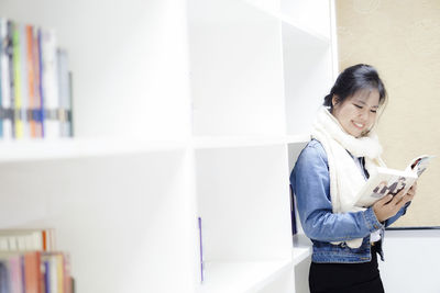 Young woman reading book at library