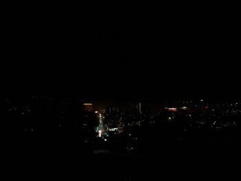 Illuminated cityscape against sky at night