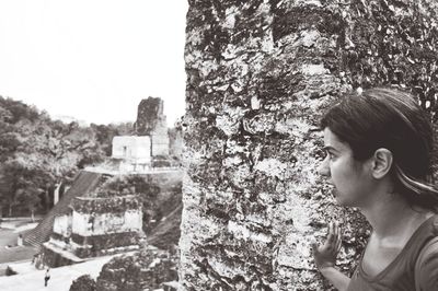 Woman standing on tree trunk