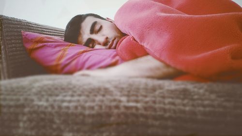 Man sleeping on bed in bedroom at home