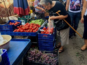 Woman buying vegetables at market stall