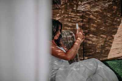 Midsection of woman sitting against wall