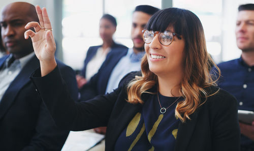 Happy businesswoman wearing eyeglasses sitting in office