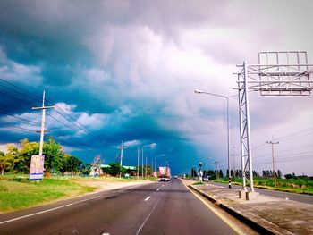 Cars on road against sky in city