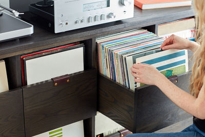 Woman sifting through vinyl record collection in custom cabinet