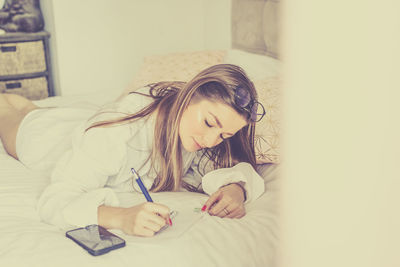 Portrait of young woman reading book at home