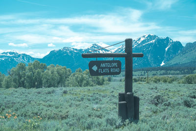 Information sign on landscape against sky