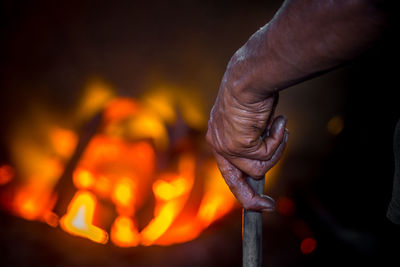 Close-up of hand holding burning candle