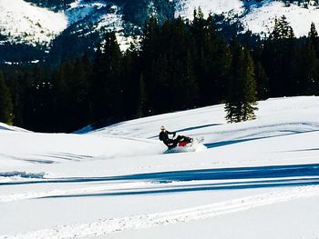 Person riding motorcycle on snow covered mountain