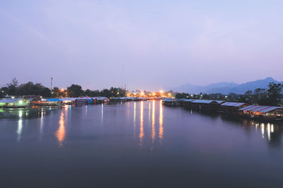 Reflection of illuminated buildings in river at sunset