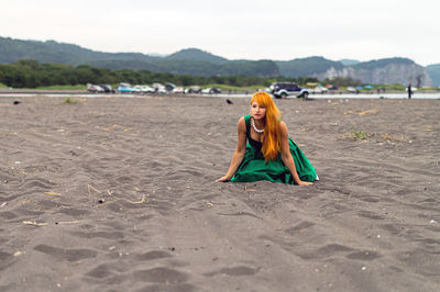 Beautiful woman kneeling at beach