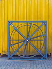 Close-up of yellow metallic structure on footpath