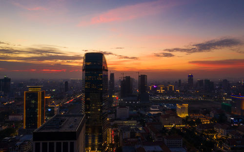 Illuminated modern buildings against sky during sunset