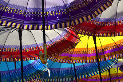 Low angle view of illuminated ferris wheel against buildings