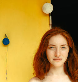 Portrait of beautiful young woman against wall