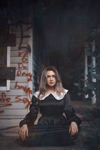 Young woman sitting with arms lowered