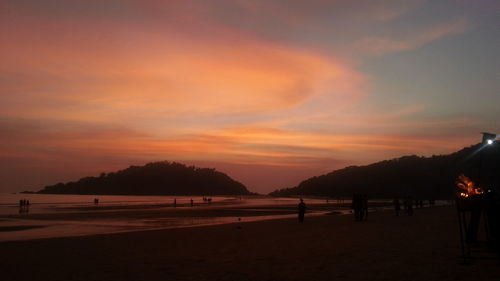 Scenic view of beach against orange sky