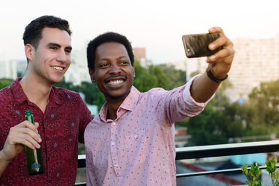 Portrait of a smiling young man using smart phone