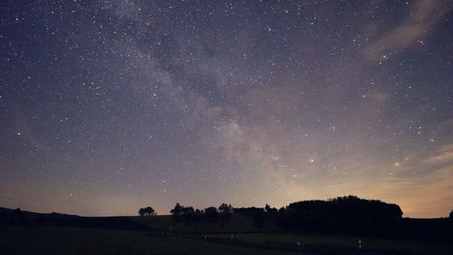 Silhouette landscape against sky at night