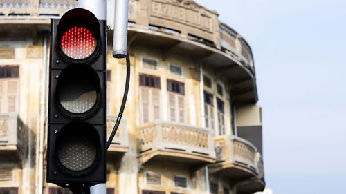 Low angle view of road signal against buildings