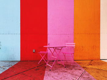 Empty chair against colorful wall in building