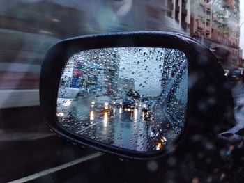 Close-up of raindrops on side-view mirror