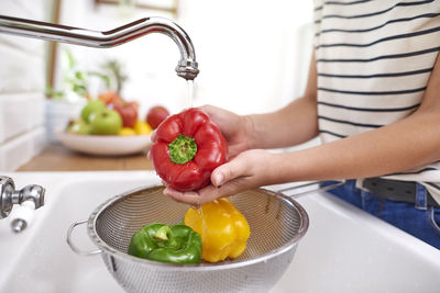 Midsection of woman with fruits and vegetables at home