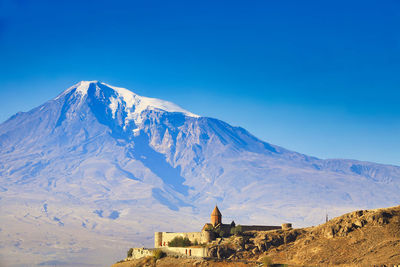 Scenic view of snowcapped mountains against blue sky