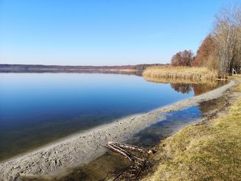 Scenic view of lake against clear blue sky