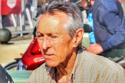 Close-up of man looking away in sunny day