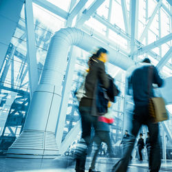 Blurred motion of people walking on footpath in city