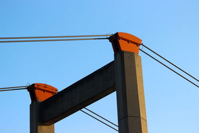 Low angle view of crane against clear blue sky