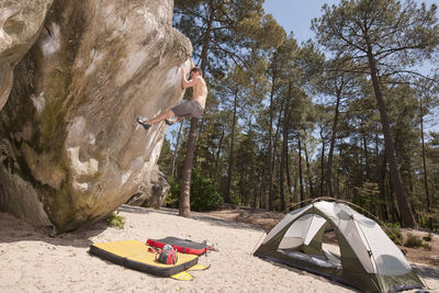 Young man bouldering in the forest of fontainebleau close to paris