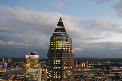 Skyscraper tower top building in city against cloudy sky, messeturm in frankfurt am main, germany