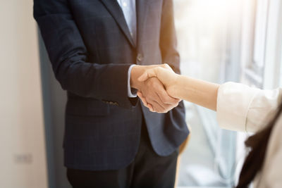 Midsection of businessman giving handshake