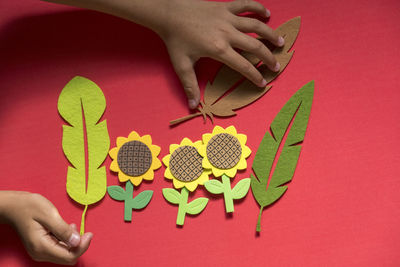 High angle view of woman holding red leaf