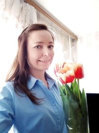 Portrait of smiling young woman holding flower bouquet