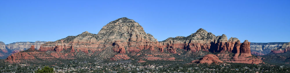 Rock formations on mountain against clear blue sky