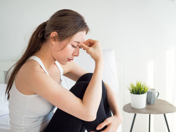 Woman suffering from headache at home