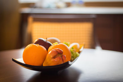 Close-up of orange fruits in plate on table