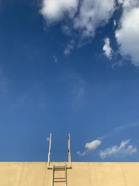 Low angle view of ladder on field against sky