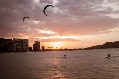 Silhouette of man flying over sea