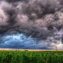 Scenic view of field against dramatic sky