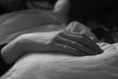 Close-up of hands on bed