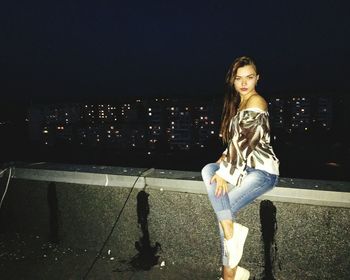 Young woman standing in illuminated city at night