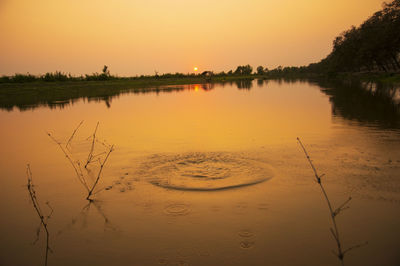 Scenic view of lake against orange sky