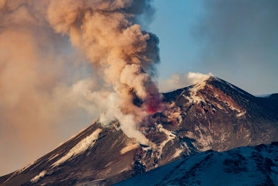 Smoke emitting from volcanic mountain against sky