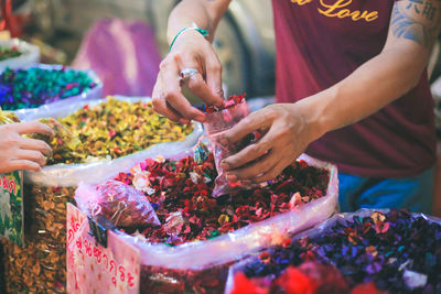 Midsection of woman holding food at market stall