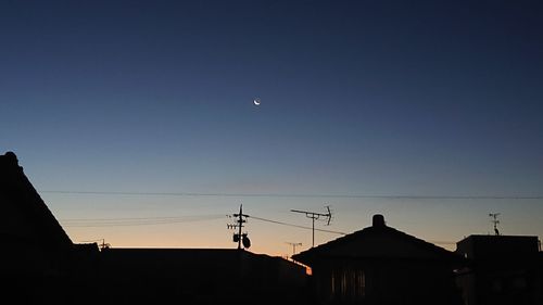 Low angle view of silhouette buildings against clear sky at dusk