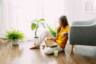 Young woman sitting on sofa at home